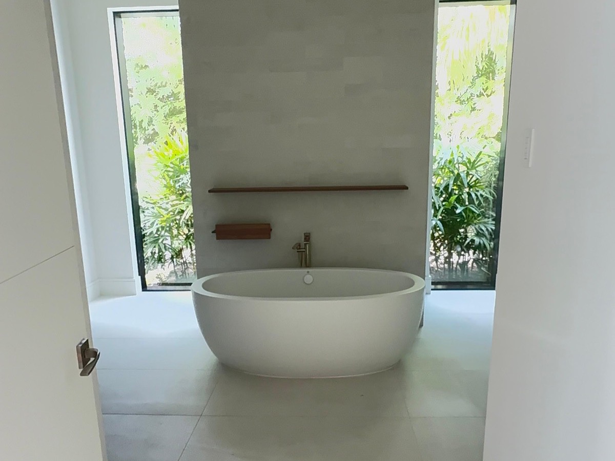 Freestanding tub with a limestone feature wall