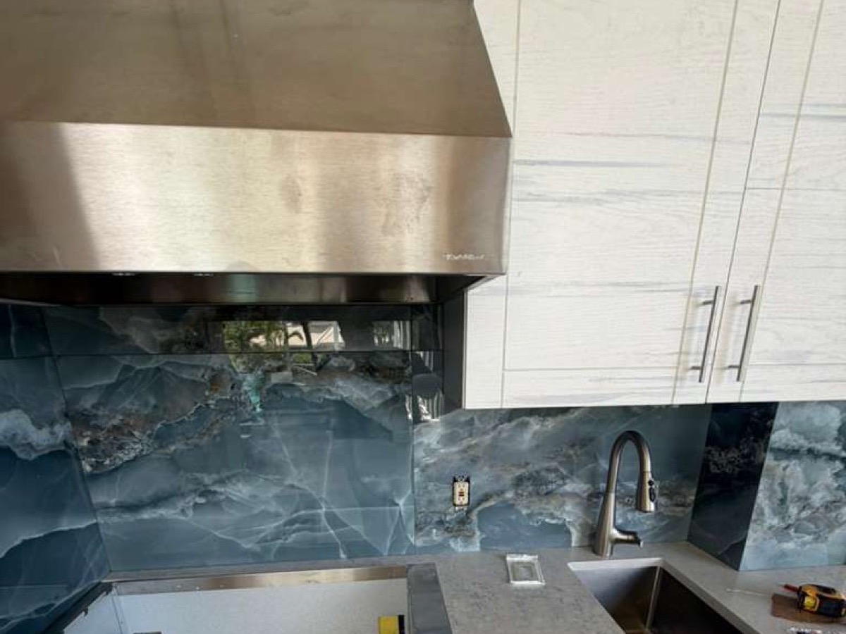 Kitchen with a full-height stone backsplash and quartz countertop