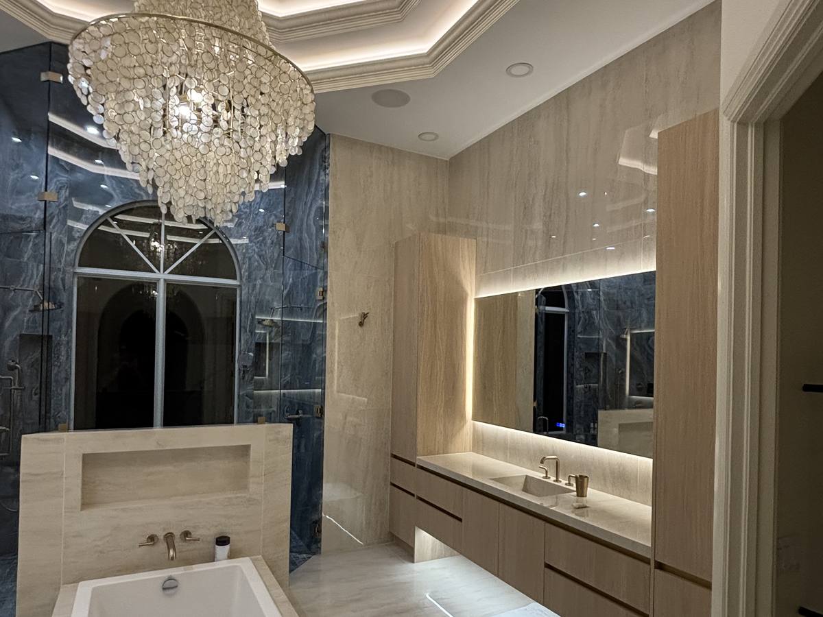 Luxury master bathroom remodel with marble accent wall and soaking tub in South Florida