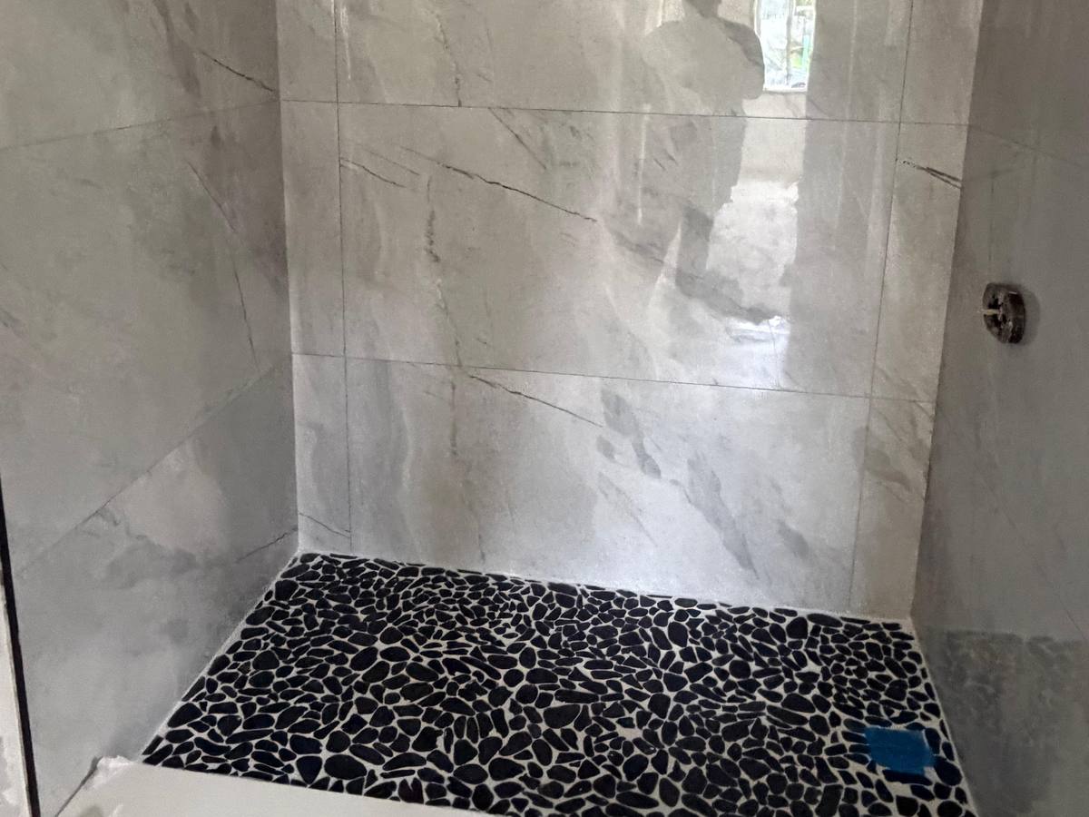 Walk-in shower with a pebble stone floor
